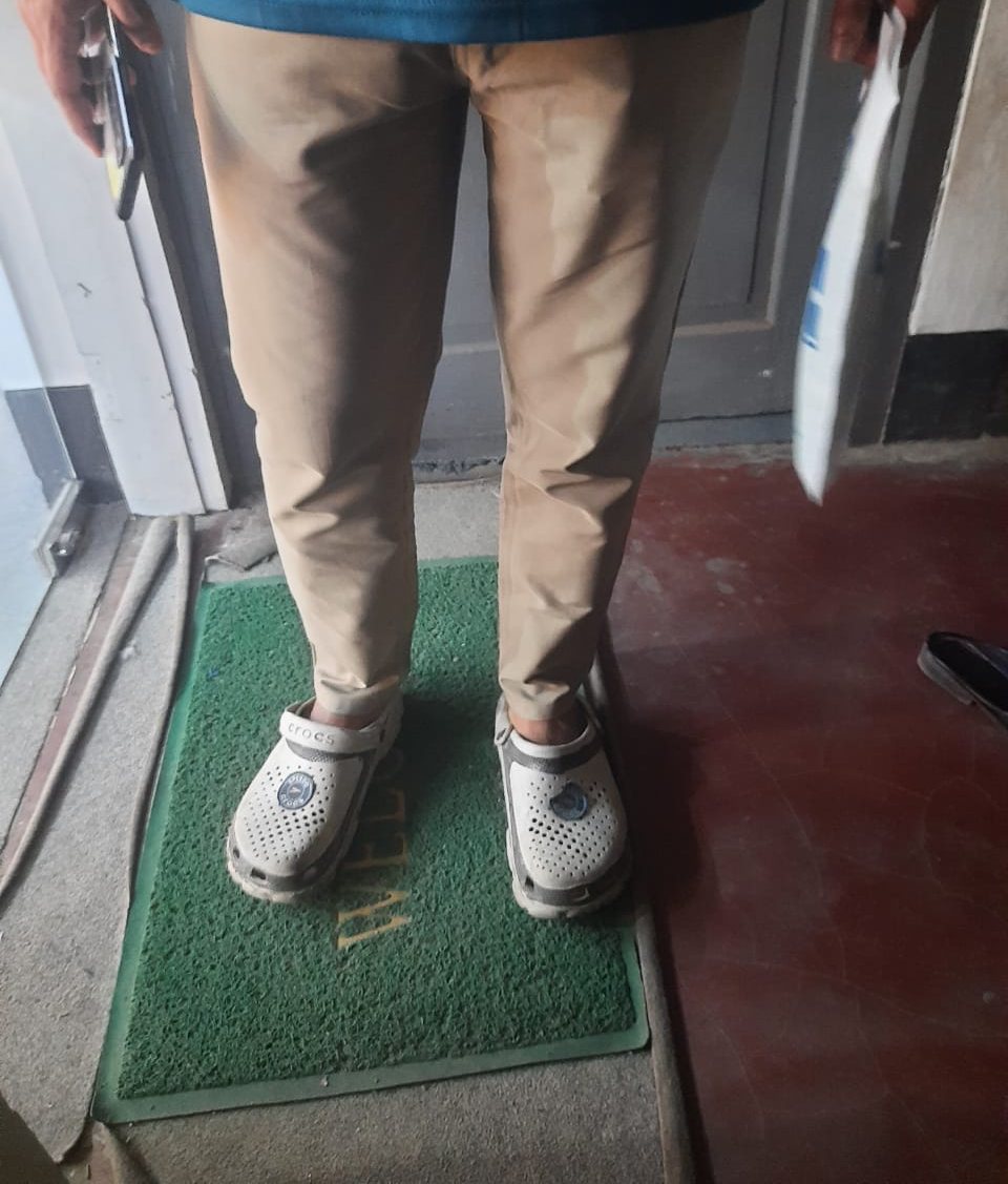 White and grey Crocs worn with slim khaki chinos and a teal T-shirt