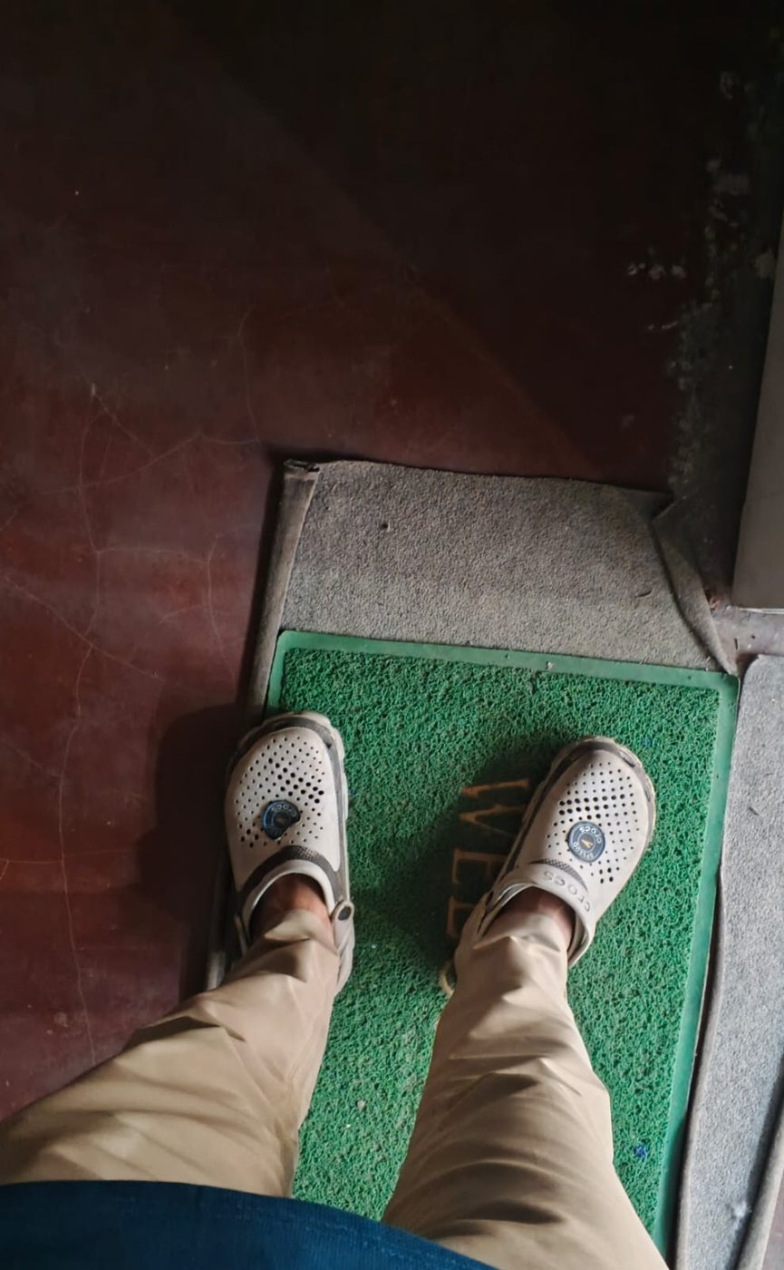 Top-down view of white Crocs with khaki chinos