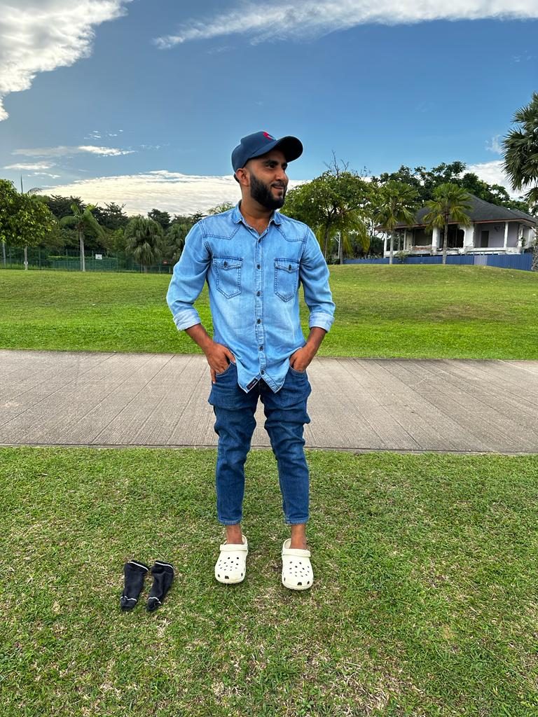 Man in Bone Crocs Classic Clogs with slim dark jeans and a light denim shirt